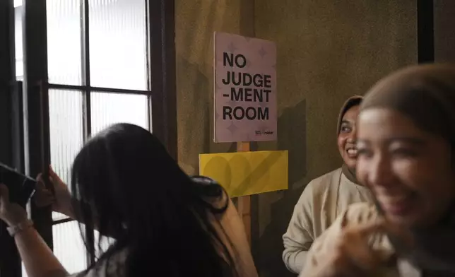 Participants enter a "No Judgement Room" where they sing and express themselves during a gathering of "Nyanyi Bareng Jakarta" or "Singing Together Jakarta" community in Jakarta, Indonesia, Saturday, July 19, 2025. (AP Photo/Dita Alangkara)