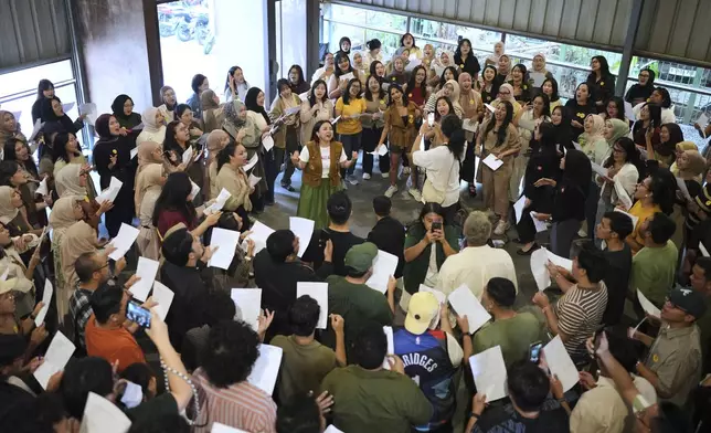 Meda Kawu, center, co-founder of Nyanyi Bareng Jakarta, or Singing Together Jakarta, leads participants during a gathering in Jakarta, Indonesia, Saturday, July 19, 2025. (AP Photo/Dita Alangkara)