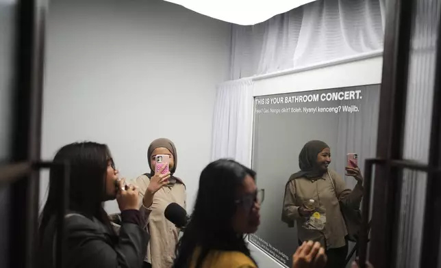 Participants enter a "No Judgement Room" where they sing and express themselves, during a gathering of "Nyanyi Bareng Jakarta" or "Singing Together Jakarta" community in Jakarta, Indonesia, Saturday, July 19, 2025. (AP Photo/Dita Alangkara)