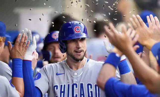 Chicago Cubs' Kyle Tucker is congratulated by teammates in the dugout after hitting a two-run home run during the third inning of a baseball game against the Los Angeles Angels, Saturday, Aug. 23, 2025, in Anaheim, Calif. (AP Photo/Mark J. Terrill)