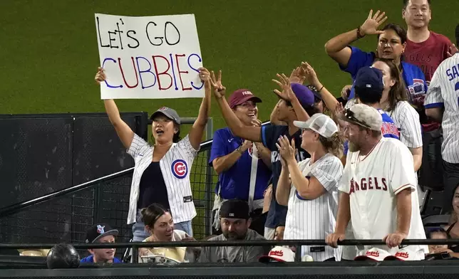 Fans cheer after Chicago Cubs' Kyle Tucker hit a three-run home run during the sixth inning of a baseball game against the Los Angeles Angels, Saturday, Aug. 23, 2025, in Anaheim, Calif. (AP Photo/Mark J. Terrill)