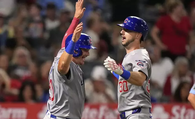 Chicago Cubs' Kyle Tucker, right, is congratulated by Reese McGuire after hitting a three-run home run during the sixth inning of a baseball game against the Los Angeles Angels, Saturday, Aug. 23, 2025, in Anaheim, Calif. (AP Photo/Mark J. Terrill)