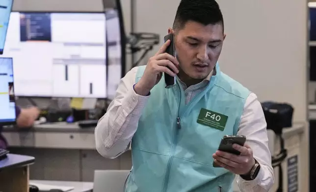 Options trader Tommy Nguyen works on the floor of the New York Stock Exchange, Monday, Aug. 18, 2025. (AP Photo/Richard Drew)