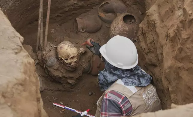 Archaeologist Jose Aliaga works at the site where city workers discovered ancient remains, from the pre-Inca Chancay culture, and artifacts as workers were digging a natural gas line for the company Calidda in the district of Puente Piedra on the outskirts of Lima, Peru, Thursday, July 31, 2025. (AP Photo/Guadalupe Pardo)