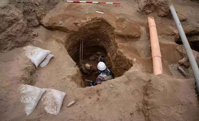 Archaeologist Jose Aliaga works at the site where city workers discovered a ancient remains, from the pre-Inca Chancay culture, and artifacts as they were digging a natural gas line for the company Calidda in the district of Puente Piedra on the outskirts of Lima, Peru, Thursday, July 31, 2025. (AP Photo/Guadalupe Pardo)