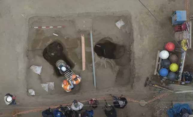 Archaeologist work at the site where city workers discovered ancient remains, from the pre-Inca Chancay culture, and artifacts as they were digging a natural gas line for the company Calidda in the district of Puente Piedra on the outskirts of Lima, Peru, Thursday, July 31, 2025. (AP Photo/Guadalupe Pardo)