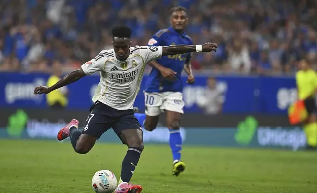 Real Madrid's Vinicius Junior assists teammate Kylian Mbappe to score during a Spanish La Liga soccer match between Real Oviedo and Real Madrid at Carlos Tartiere stadium in Oviedo, Spain, Sunday, Aug. 24, 2025. (AP Photo/Miguel Oses)