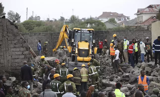 Firefighters search near the debris at the site of an airplane belonging to the African Medical and Research Foundation (AMREF) that crashed into a residential building in the Mwihoko area of Ruiru, in Kiambu County, Kenya, Wednesday, Aug. 7, 2024. (AP Photo/Patrick Ngugi)