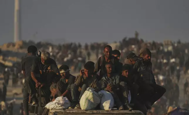 Palestinians carry sacks of flour unloaded from a humanitarian aid convoy that reached Gaza City from the northern Gaza Strip, Sunday, Aug. 24, 2025. (AP Photo/Abdel Kareem Hana)