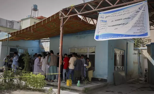 Men wait in line to register for a Qatar work visa for unemployed Afghans expelled from neighbouring countries, outside a registration center in Kabul, Afghanistan, Wednesday Aug. 13, 2025. (AP Photo/Siddiqullah Alizai)