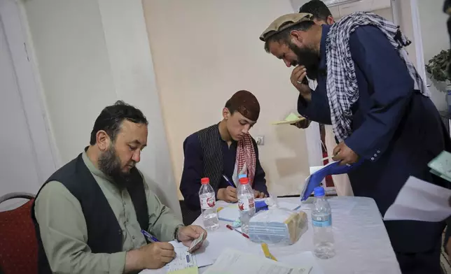 Men register for Qatar work visas for unemployed Afghans expelled from neighboring countries, outside a registration center in Kabul, Afghanistan, Wednesday, August 13, 2025. (AP Photo/Siddiqullah Alizai)