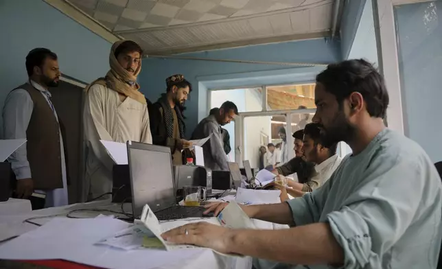 Men register for Qatar work visas for unemployed Afghans expelled from neighboring countries, outside a registration center in Kabul, Afghanistan, Wednesday, August 13, 2025. (AP Photo/Siddiqullah Alizai)