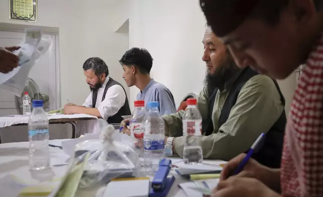 Men register for Qatar work visas for unemployed Afghans expelled from neighboring countries, outside a registration center in Kabul, Afghanistan, Wednesday, August 13, 2025. (AP Photo/Siddiqullah Alizai)