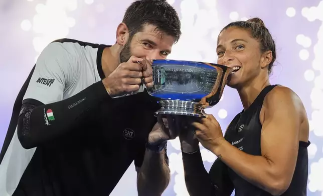 Andrea Vavassori, left, of Italy, and Sara Errani, of Italy, hold up the championship trophy after defeating Iga Swiatek, of Poland, and Casper Ruud, of Norway, in the mixed doubles final at the U.S. Open tennis championships, Wednesday, Aug. 20, 2025, in New York. (AP Photo/Yuki Iwamura)