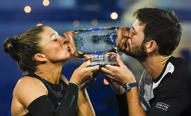 Andrea Vavassori, right, of Italy, and Sara Errani, left, of Italy, hold up the championship trophy after defeating Iga Swiatek, of Poland, and Casper Ruud, of Norway, in the mixed doubles final at the U.S. Open tennis championships, Wednesday, Aug. 20, 2025, in New York. (AP Photo/Yuki Iwamura)
