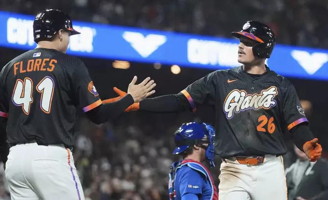 San Francisco Giants' Matt Chapman (26) celebrates after hitting a two-run home run that also scored Wilmer Flores (41) during the sixth inning of a baseball game against the Chicago Cubs in San Francisco, Tuesday, Aug. 26, 2025. (AP Photo/Jeff Chiu)