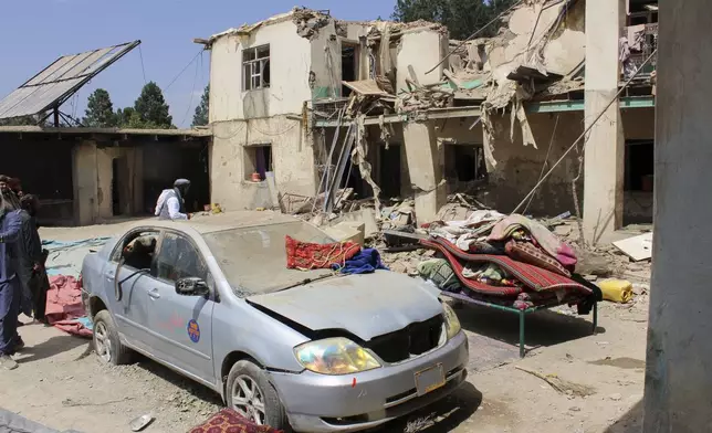 Residents inspect the site of a building destroyed in what Taliban authorities said was a Pakistani drone attack that killed eight civilians, including three children, in Spera district of Khost province, Afghanistan, Thursday, Aug. 28, 2025. (AP Photo/Saifullah Zahir)