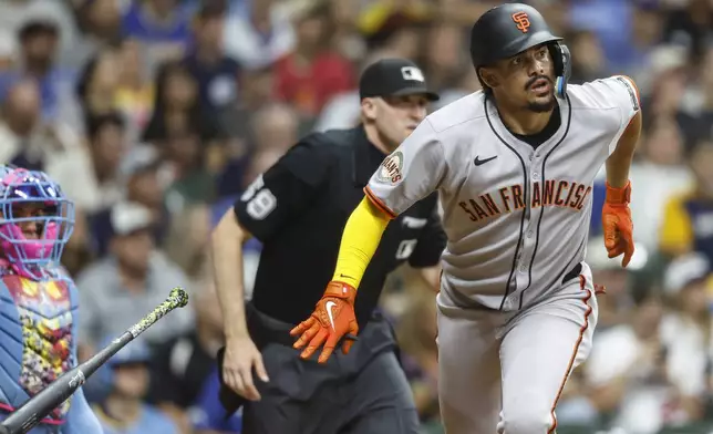 San Francisco Giants' Willy Adames, right, watches his home run during the eighth inning of a baseball game against the Milwaukee Brewers, Friday, Aug. 22, 2025, in Milwaukee. (AP Photo/Jeffrey Phelps)