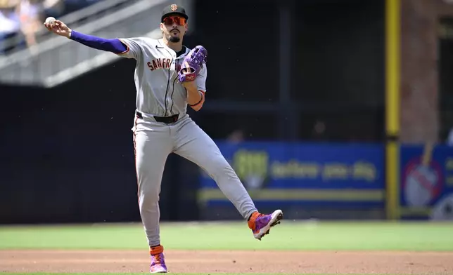 San Francisco Giants shortstop Willy Adames throws to first base on a groundout hit by San Diego Padres' Xander Bogaerts during the second inning of a baseball game Thursday, Aug. 21, 2025, in San Diego. (AP Photo/Orlando Ramirez)