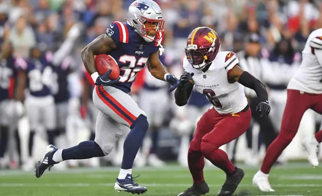 New England Patriots running back TreVeyon Henderson (32) runs the ball back for a touchdown against Washington Commanders cornerback Noah Igbinoghene (6) during the first half of an NFL preseason football game Friday, Aug. 8, 2025, in Foxborough, Mass. (AP Photo/Steven Senne)