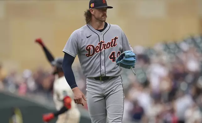 Detroit Tigers starting pitcher Chris Paddack, foreground, stands on the field as Minnesota Twins' Byron Buxton, back left, runs the bases after hitting a solo home run during the third inning of a baseball game Sunday, Aug. 17, 2025, in Minneapolis. (AP Photo/Abbie Parr)