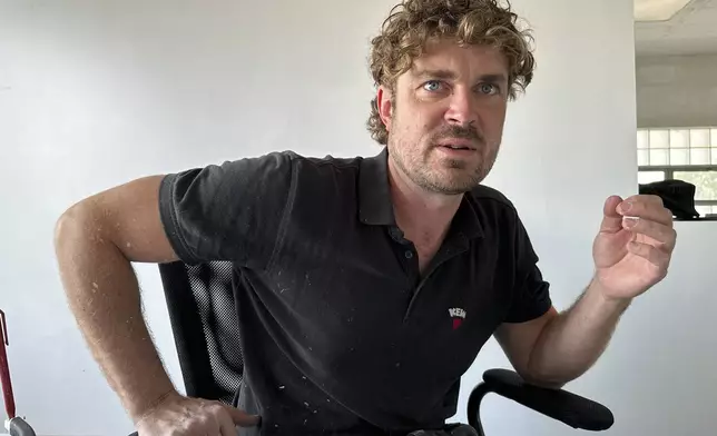 Artist Guido van Helten discusses his murals on Monday, July 14, 2025, in Minot, N.D. (AP Photo/Jack Dura)