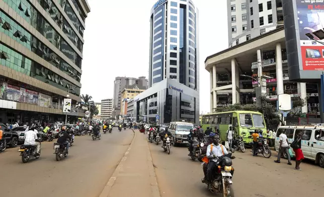 FILE - Drivers of motorcycle taxis, known locally as boda-bodas, ride with passengers on a street of Kampala, Uganda, on July 18, 2024. (AP Photo/Hajarah Nalwadda, File)