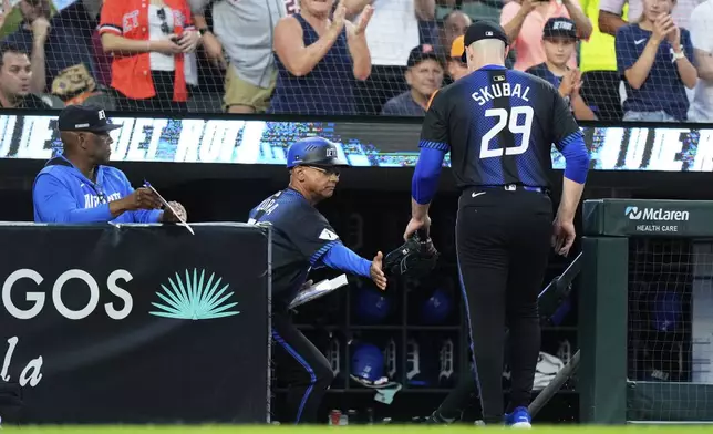 Detroit Tigers starting pitcher Tarik Skubal, right, is greeted by third base coach Joey Cora after being pulled out during the fifth inning of a baseball game against the Los Angeles Angels, Friday, Aug. 8, 2025, in Detroit. (AP Photo/Ryan Sun)