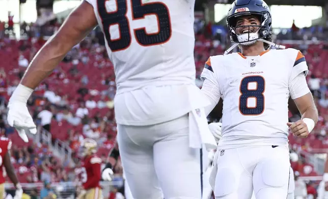 Denver Broncos tight end Lucas Krull (85) celebrates his touchdown catch with quarterback Jarrett Stidham (8) during the first half of a preseason NFL football game Saturday, Aug. 9, 2025, in Santa Clara, Calif. (AP Photo/Kelley L Cox)