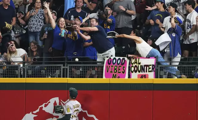 Fans cheer as the solo home run ball from Seattle Mariners' Jorge Polanco flies over the fence past Athletics right fielder JJ Bleday during the seventh inning of a baseball game Friday, Aug. 22, 2025, in Seattle. (AP Photo/Lindsey Wasson)