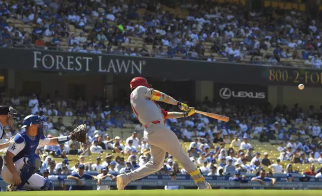 St. Louis Cardinals' Lars Nootbaar hits an RBI double as Los Angeles Dodgers catcher Will Smith watches during the ninth inning of a baseball game Wednesday, Aug. 6, 2025, in Los Angeles. (AP Photo/Mark J. Terrill)