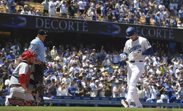 Los Angeles Dodgers' Shohei Ohtani, right, scores after hitting a two-run home run and his 1,000th hit as St. Louis Cardinals catcher Pedro Pages watches during the third inning of a baseball game Wednesday, Aug. 6, 2025, in Los Angeles. (AP Photo/Mark J. Terrill)