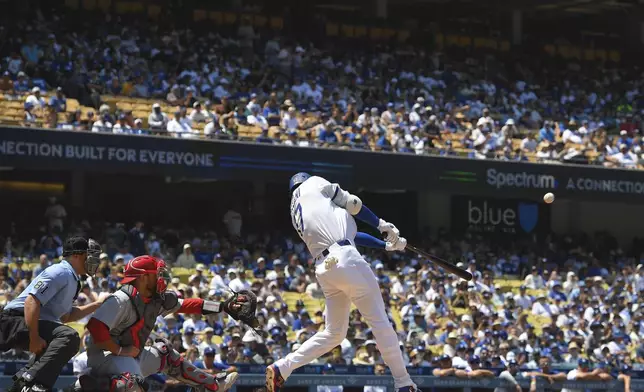 Los Angeles Dodgers' Shohei Ohtani, right, hits a two-run home run and his 1,000th hit as St. Louis Cardinals catcher Pedro Pages watches during the third inning of a baseball game Wednesday, Aug. 6, 2025, in Los Angeles. (AP Photo/Mark J. Terrill)