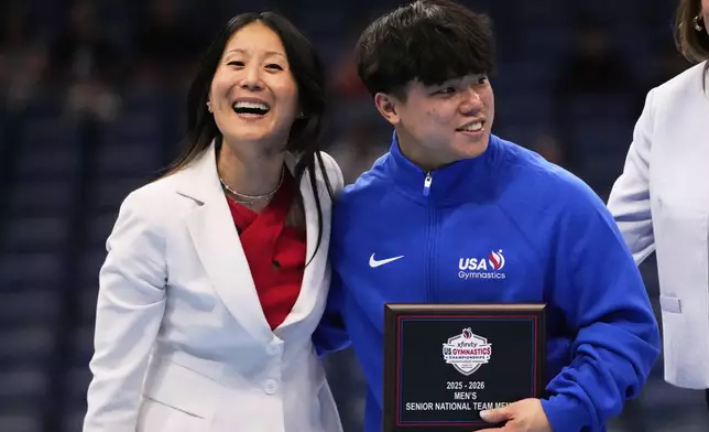 USA Gymnastics president Li Li Leung poses with overall winner Asher Hong of Stanford University after the senior men's finals of the U.S. Gymnastics Championships in New Orleans, Saturday, Aug. 9, 2025. (AP Photo/Gerald Herbert)