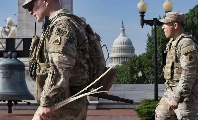 National Guard personnel keep watch as travelers arrive at the entrance to Union Station near the Capitol in Washington, Thursday, Aug. 14, 2025. (AP Photo/J. Scott Applewhite)