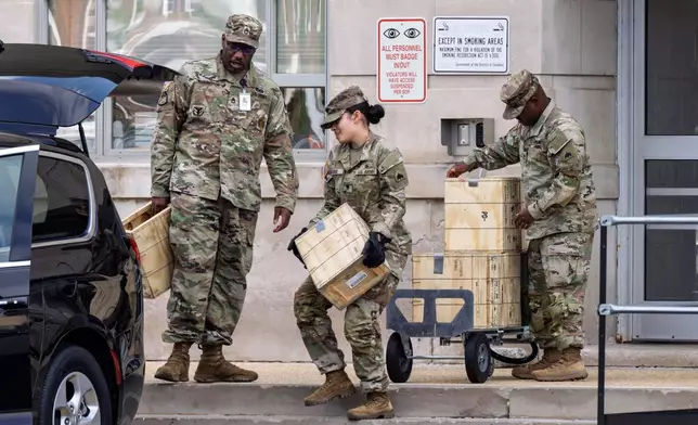 Troops load boxes of rifle ammunition at the District of Columbia National Guard Headquarters as President Donald Trump implements his order to use federal law enforcement and the National Guard to expel homeless people and rid the nation's capital of violent crime, in Washington, Tuesday, Aug. 12, 2025. (AP Photo/J. Scott Applewhite)