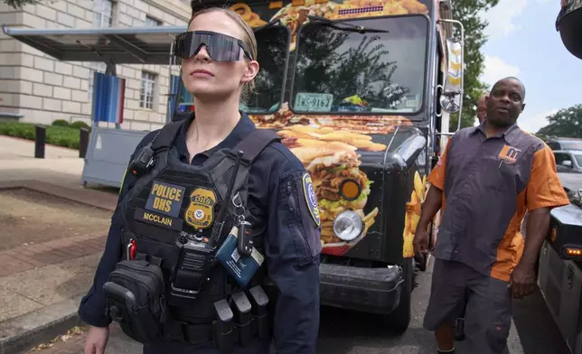 Department of Homeland Security Federal Protective Services agents instruct a tow truck to take away a food truck on the National Mall, Friday, Aug. 15, 2025, in Washington. The owner says his employees were asked for immigration status by ICE and then he was told that the truck's tires were bad and it would have to be towed. (AP Photo/Jacquelyn Martin)