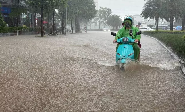 Streets of the capital city, Hanoi, are flooded due to heavy rain after Typhoon Kajiki passed through Vietnam, Tuesday, Aug. 26, 2025. (AP Photo/Hau Dinh)