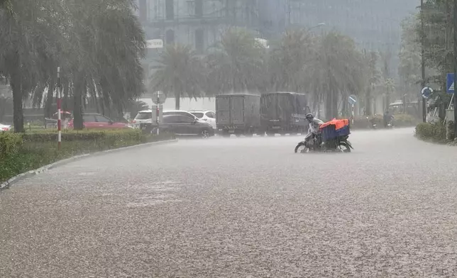 Streets of the capital city, Hanoi, are flooded due to heavy rain after Typhoon Kajiki passed through Vietnam, Tuesday, Aug. 26, 2025. (AP Photo/Hau Dinh)
