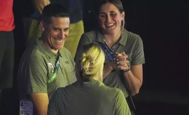 United States team leader Greg Meehan, left, chats with his colleagues during the World Aquatics Championships in Singapore, Friday, Aug.1, 2025. (AP Photo/Ng Han Guan)