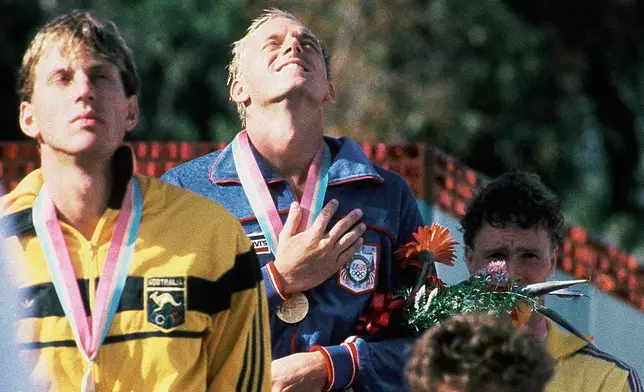 FILE - America's Rowdy Gaines, gold medal, Mark Stockwell of Australia, silver medal, and Per Johansson of Sweden, bronze medal, on the podium after the Men's 100 Meter Freestyle Swimming Event at the Summer Olympic Games in Los Angeles, on July 31, 1984. (AP Photo/Ron Edmonds, File)