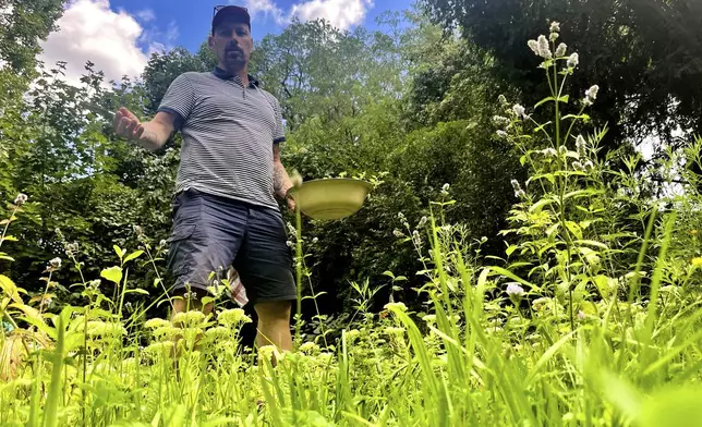 Martin Roetzel, owner of 'The Monk Garden' stands between different plants in Berlin, Germany, Sunday, Aug. 17, 2025. (AP Photo/Fanny Brodersen)