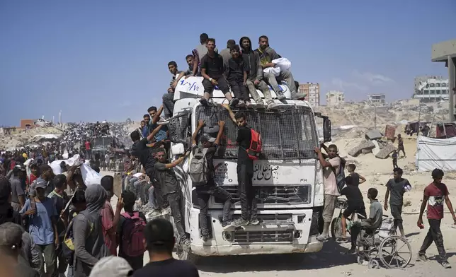 Palestinians carry sacks of flour taken from a humanitarian aid convoy en route to Gaza City, in the outskirts of Beit Lahiya, northern Gaza Strip, Friday, Aug. 1, 2025. (AP Photo/Jehad Alshrafi)