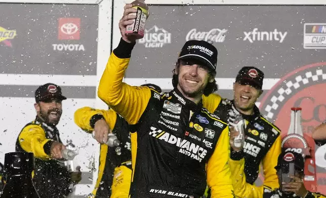 Ryan Blaney, front, celebrates in Victory Lane after winning a NASCAR Cup Series auto race at Daytona International Speedway, Saturday, Aug. 23, 2025, in Daytona Beach, Fla. (AP Photo/John Raoux)
