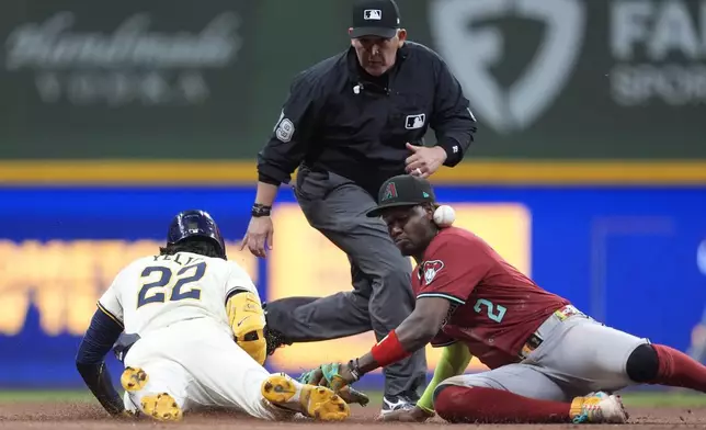 Milwaukee Brewers' Christian Yelich (22) slides safely into second base for a double past Arizona Diamondbacks' Geraldo Perdomo (2) during the eighth inning of a baseball game, Wednesday, Aug. 27, 2025, in Milwaukee. (AP Photo/Aaron Gash)