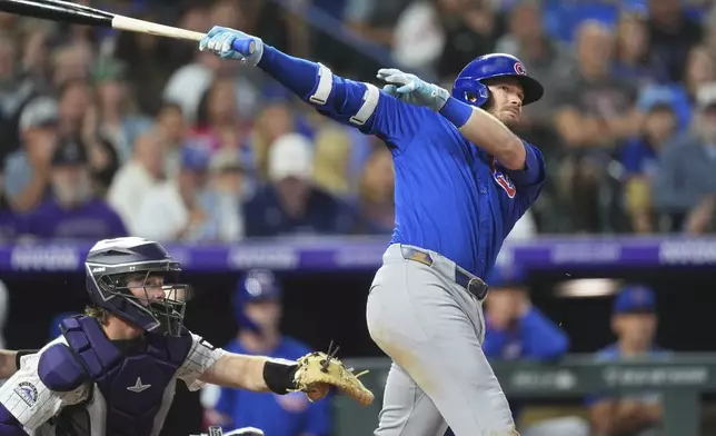 Chicago Cubs' Ian Happ, right, follows the flight of his RBI double off Colorado Rockies starting pitcher McCade Brown in the fifth inning of a baseball game Saturday, Aug. 30, 2025, in Denver. (AP Photo/David Zalubowski)
