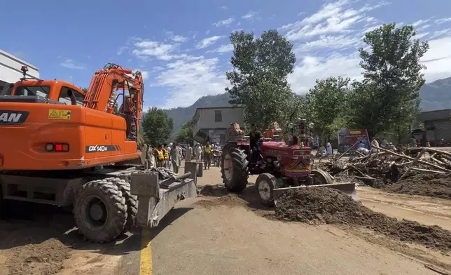 Worker with tractor remove duck from a road after Friday's flash flood hit the area of Qadar Nagar in Buner district, in Pakistan's northwest, Monday, Aug. 18, 2025. (AP Photo/Mohammad Arif)