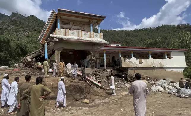 Local resident look a damaged house at after Friday's flash flood hit the area of Qadar Nagar in Buner district, in Pakistan's northwest, Monday, Aug. 18, 2025. (AP Photo/Mohammad Arif)