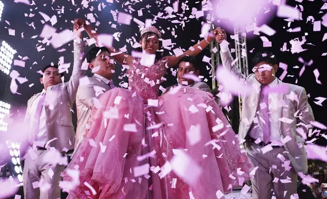 Confetti falls over Isela Santiago Morales during her 15th birthday party at a stadium in Axtla de Terrazas, Mexico, Saturday, Aug. 23, 2025, organized by the community after her father's social media appeal drew support following her first sparsely attended celebration. (AP Photo/Mauricio Palos)