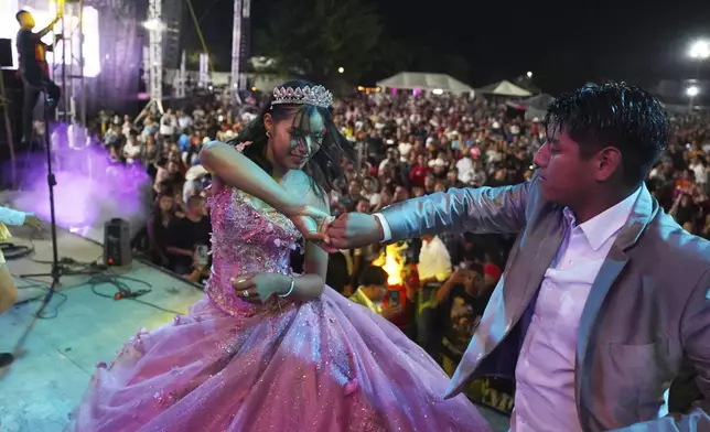 Isela Anali Santiago Morales dances during her 15th birthday party at a stadium in Axtla de Terrazas, Mexico, Saturday, Aug. 23, 2025, organized by the community after her father's social media appeal drew support following her first sparsely attended party. (AP Photo/Mauricio Palos)